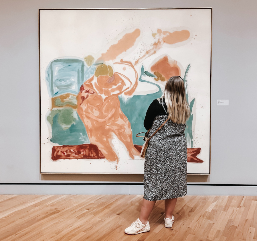 Frau betrachtet abstraktes Gemälde im Museum.